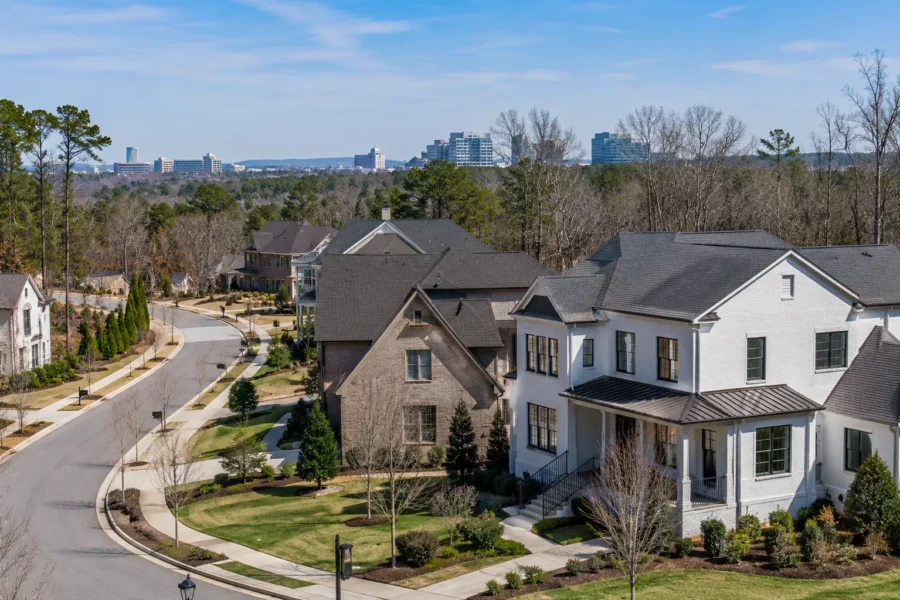 An aerial view of a new subdivision street with the skyline in the distance