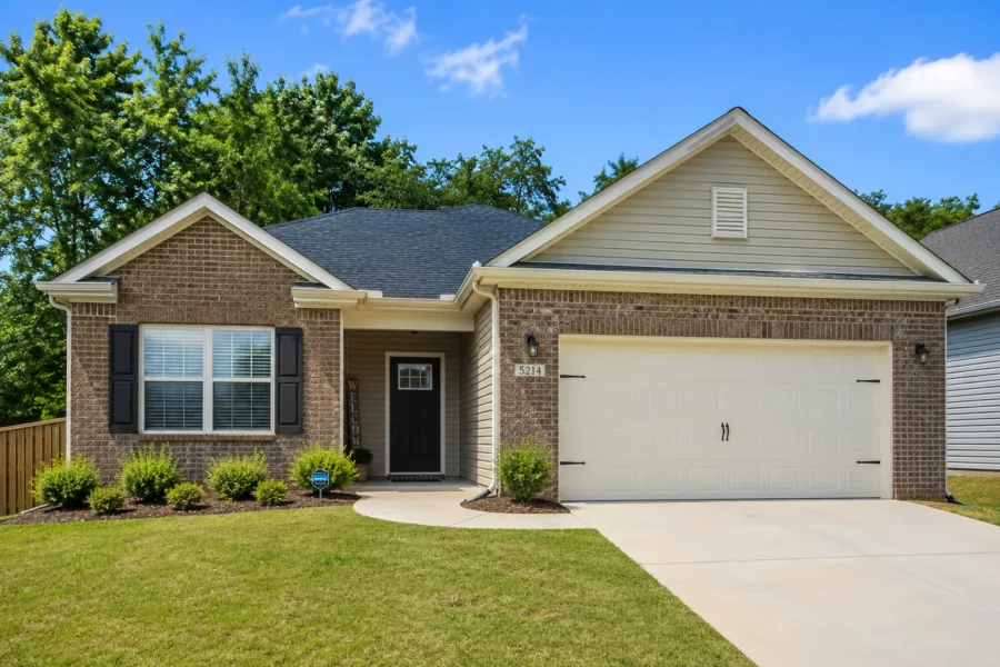 A brick and siding ranch house with a two-car garage and a short concrete drive