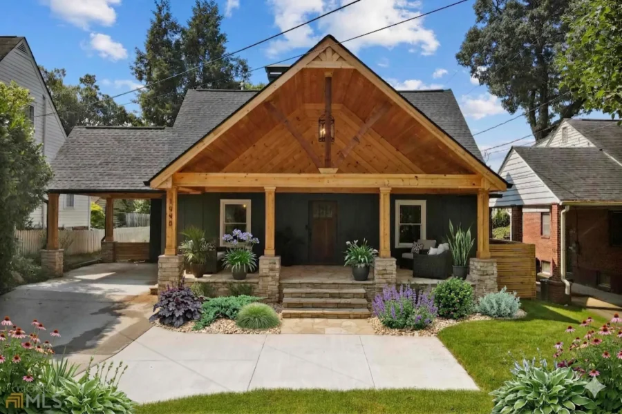 A Craftsman bungalow with a heavy timber porch gable and a paved front walk