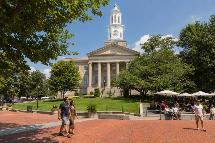Classical courthouse with a clock tower and cupola across a green plaza
