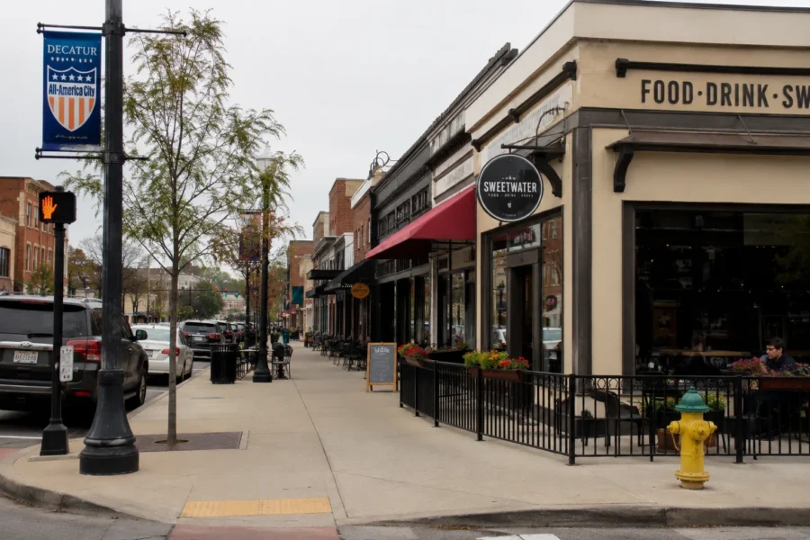 A downtown Decatur street corner with brick storefronts, banners and outdoor seating