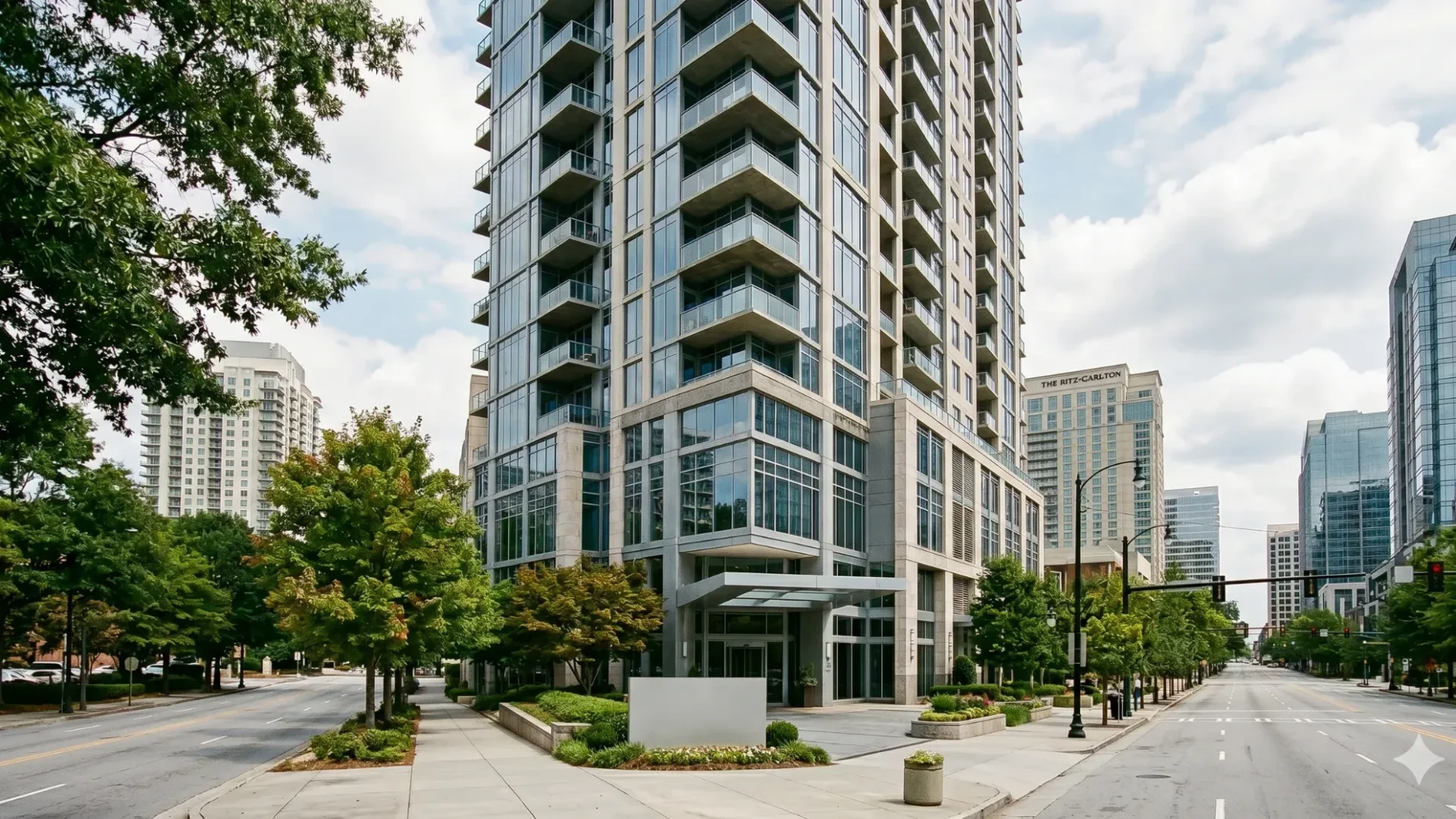 A glass condominium tower on a wide city street
