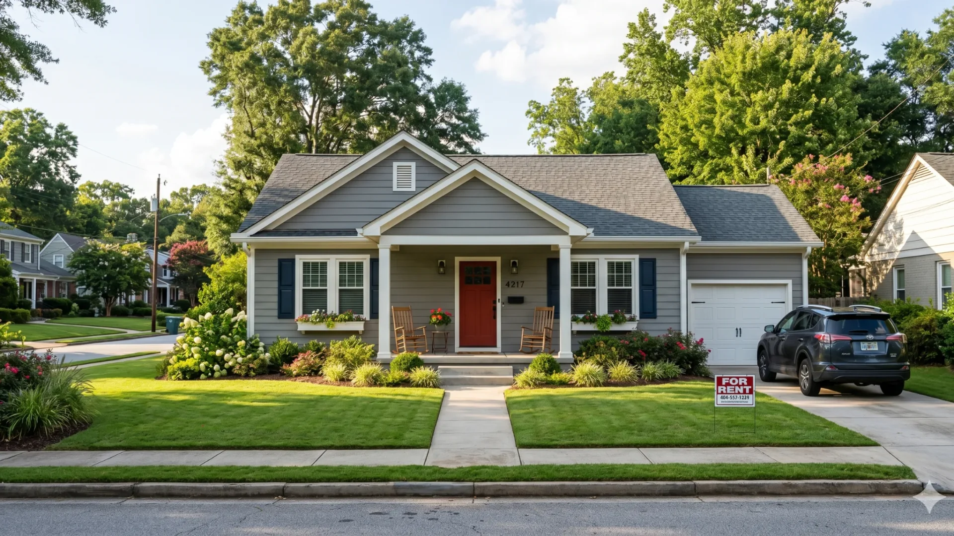 Grey craftsman two-story with a covered porch and garage on a suburban street