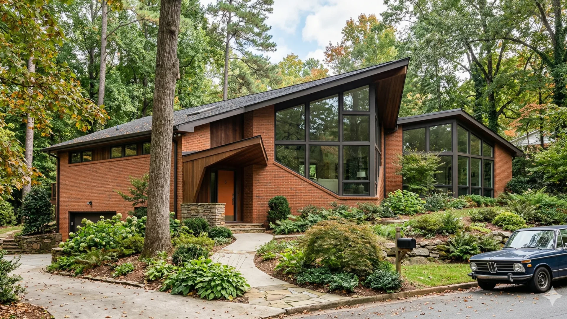 Angular mid-century modern with glass gables, brick and a carport
