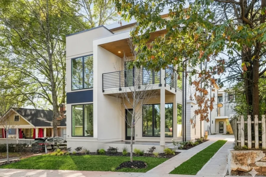 White modern infill with a wood soffit beside an older cottage
