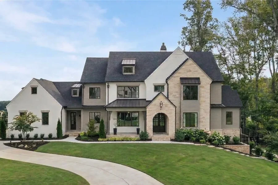 A stone and stucco house with steep gables and an arched front entry