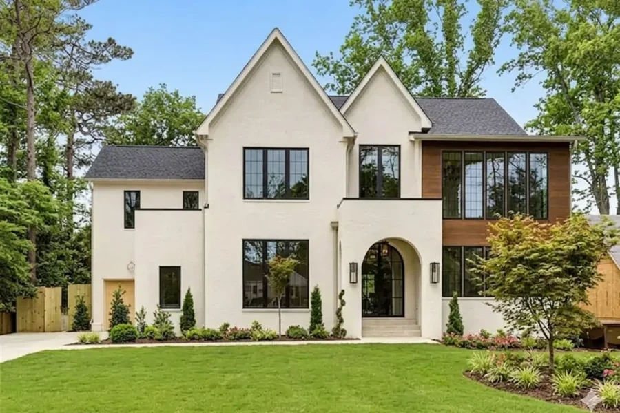 Cream stucco transitional two-story with black windows and a wood-clad bay