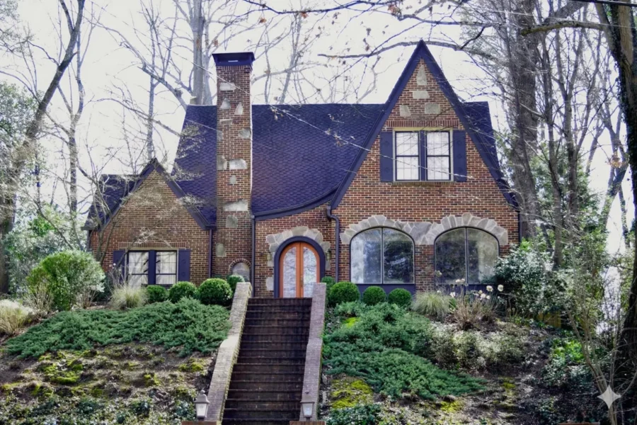 Brick and stone Tudor cottage with an arched door and stone steps