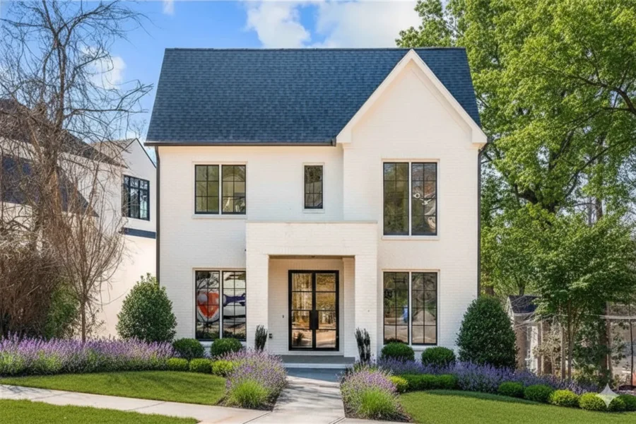 White stucco two-story with tall black-framed windows and lavender borders