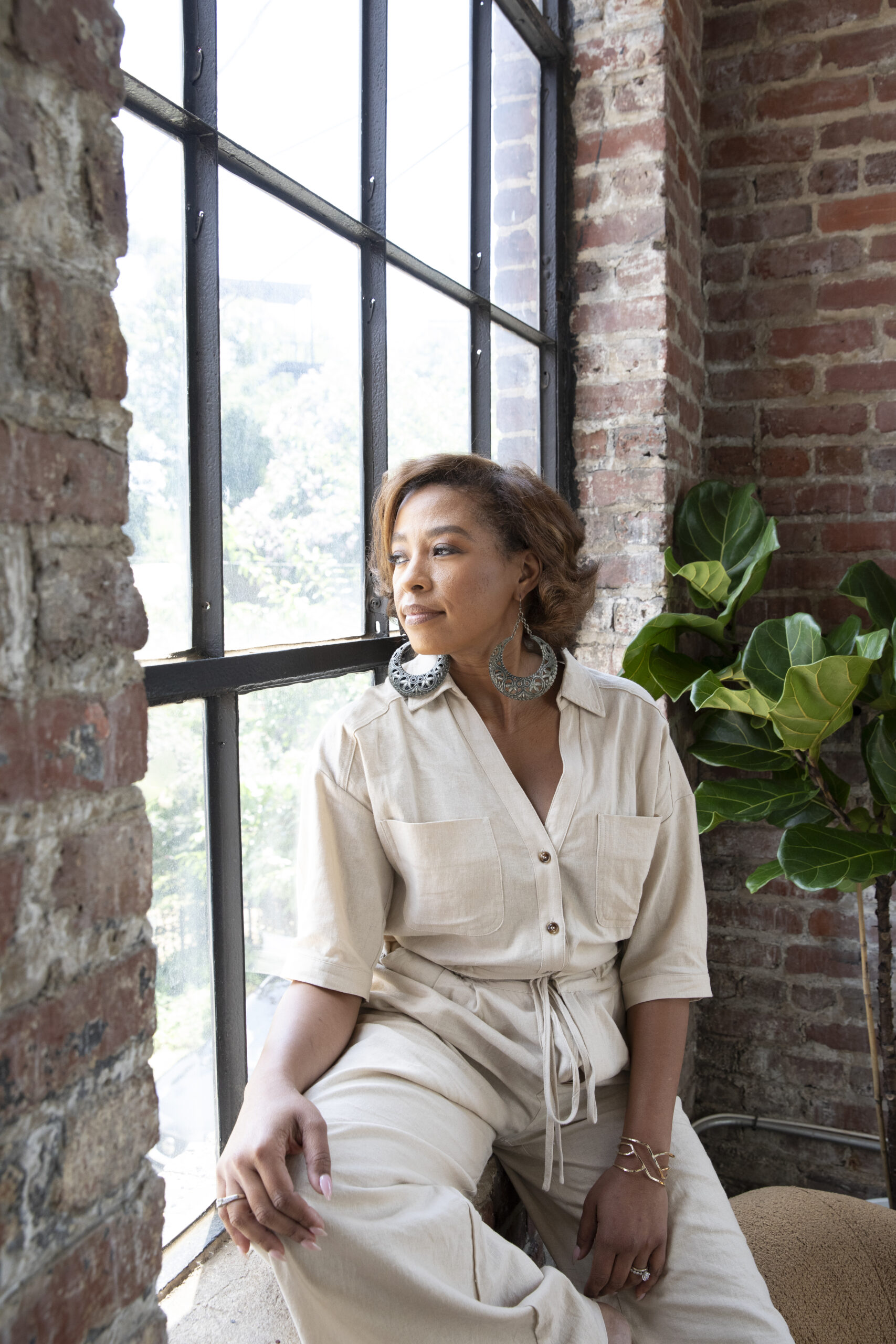 Kristen Johnson at a tall loft window, looking out over the street