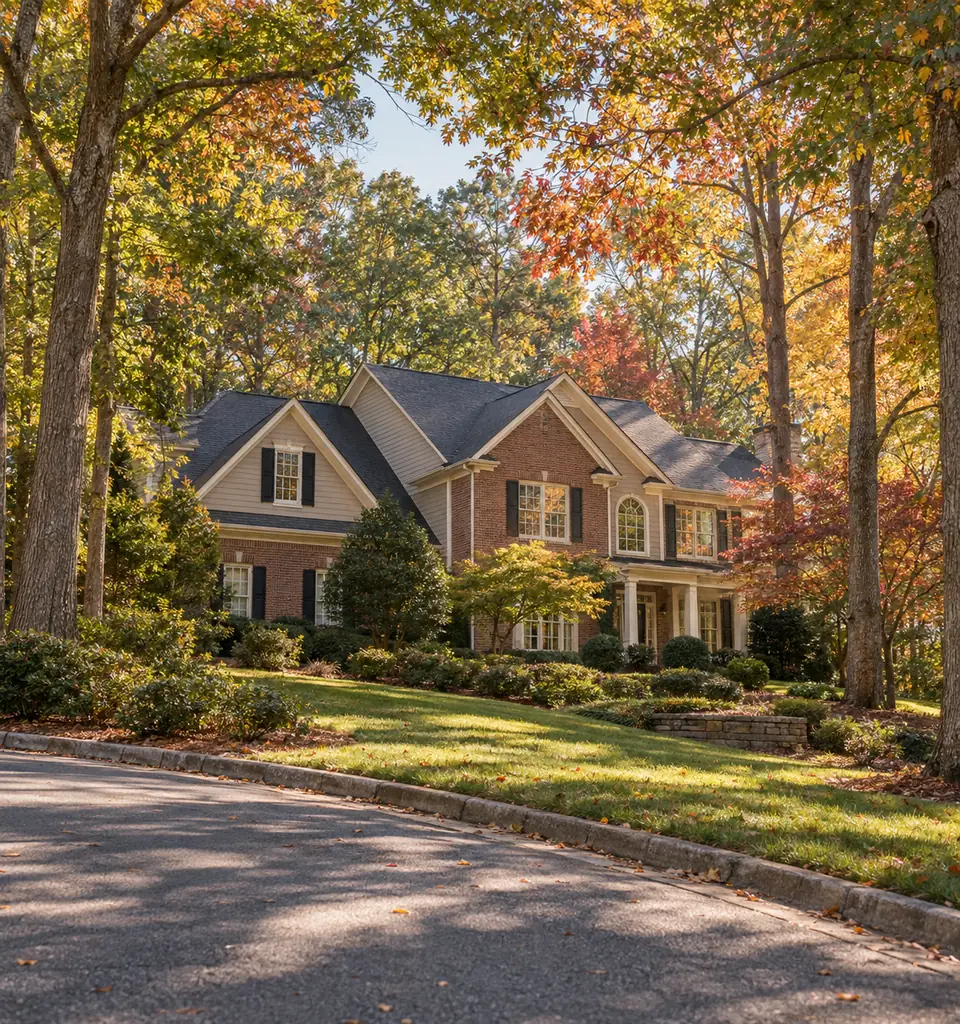 A traditional brick two story home set back on a wooded East Cobb lot under mature hardwoods in early autumn